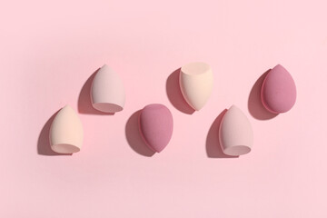 Many makeup sponges on pink background