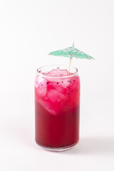 A glass of pink drink with a green umbrella on top. The drink is served in a tall glass and has a straw in it