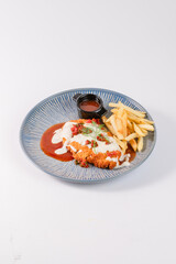 A plate of food with a piece of chicken and french fries. The plate is blue and white