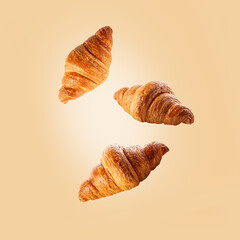 Croissant levitation on light yellow background