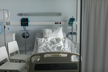 A clean and organized hospital room equipped with a bed and essential medical equipment