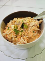 Spicy chicken noodle soup in a bowl.