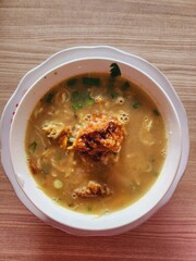 Bowl of flavorful noodle soup with crispy topping.