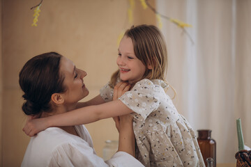Mother and daughter together, beautiful and happy in dresses, at home