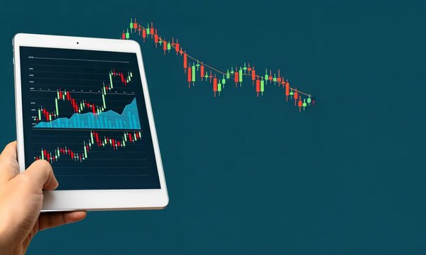 Hand holding tablet displaying financial graphs on blue background
