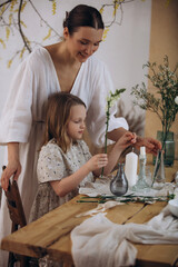 Mother and daughter together, beautiful and happy in dresses with flowers, at home