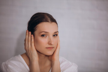 Female model brunette young adult in white dress portrait with hands