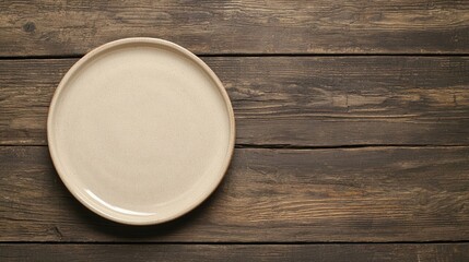 A simple, beige plate sits on a rustic wooden surface, highlighting natural textures and minimalistic design.