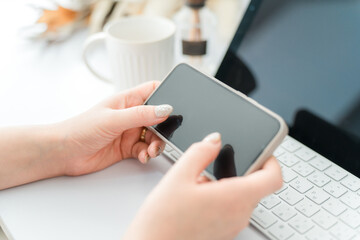 スマホ・スマートフォンの横向きの画面を見るネイルをした女性
