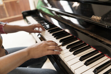 Girl learn to play piano. woman hand playing piano . © Charlie's