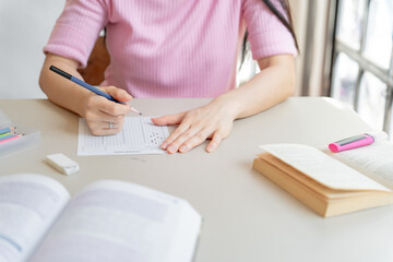 Asian girl student doing exam hand holding pencil writing answer in university classroom education high school or university student taking notes while preparing for exam