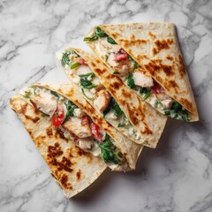 Appetizing chicken spinach and feta quesadilla triangles on a marble background in an overhead shot