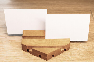 White blank business card mockup with wooden decoration on wooden background