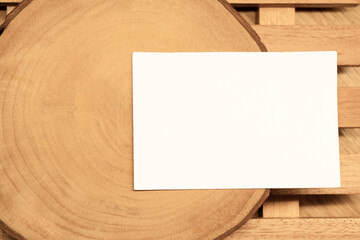 White blank business card mockup with wooden decoration on wooden background