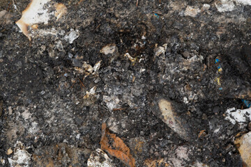 Abstract texture of charred and ashen remains after a fire incident