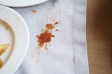 Spill on a tablecloth near empty plates after a hearty meal gathering