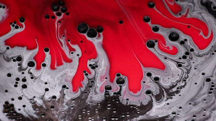 Paint spill. Bubble liquid. Defocused red silver color fluid water enamel emulsion dark black drop moving on abstract art background.