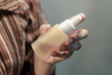 Hand holding a skincare bottle