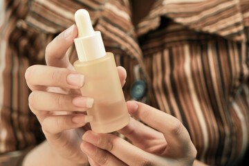 Hand holding a skincare bottle