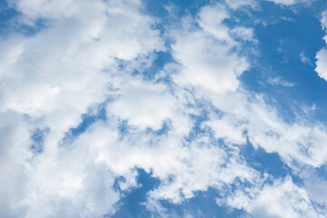Clear blue sky with a few clouds. The sky is very bright and the clouds are scattered throughout.	
