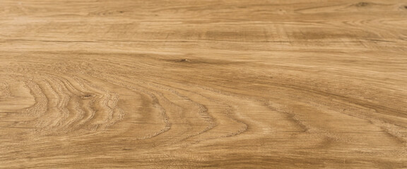 Close-up of a light brown wooden surface showing natural grain patterns. Elegant photo with detailed texture for the background.