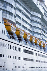 Many yellow life boats on a white tall tourist cruise liner , close up shot