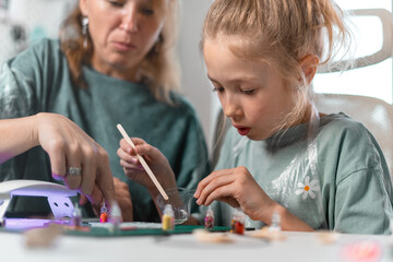 Exciting chemistry-inspired activity as girl observes transformation of liquid resin into solid with UV exposure. Creative hands-on learning combines art with scientific discovery.