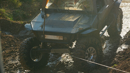 Off-road vehicle prepared for serious off-roading, with the help of a winch overcomes difficult terrain. The vehicle has large wheels with aggressive tread.