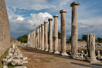 The iconic ruins of the Asklepion Heroon reveal majestic columns standing tall under bright sky. This historical site showcases ancient Greek architecture and rich heritage in Pergamon, Izmir, Turkey