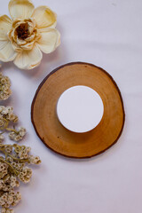 A minimalist and serene flat lay composition featuring a white, round cosmetic jar or container...