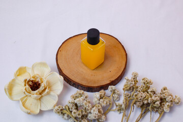 A minimalist product shot showcases a rectangular, transparent bottle filled with a vibrant yellow...