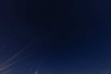 A clear night sky filled with visible stars gradually fades into a soft horizon glow, creating a...