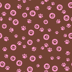 Vector hand drawn seamless pattern. Arranged paw prints of pets in polka dots pink color on brown background