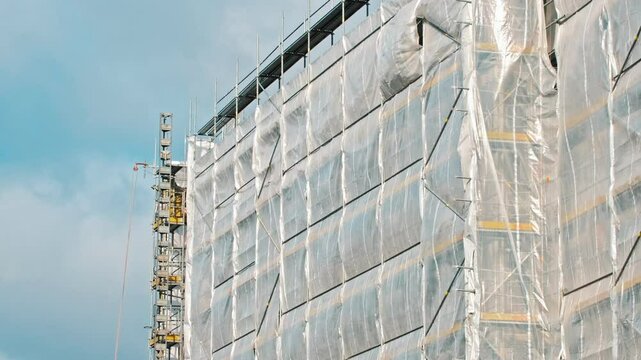 Industrial Scaffolding Secured with Safety Net Tarp at Multi Storey Residetial Building Construction Site