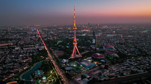 A drone over the evening streets of Tashkent against the backdrop of a sunset. View of the TV Tower