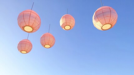 Obraz premium Pink paper lanterns float in a clear blue sky.