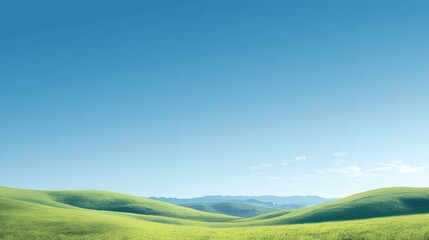 Obraz premium Green Grass Hills Landscape with Blue Sky and Distant Mountains