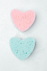 Obraz premium Colorful heart-shaped sponges lying on a light surface for cleaning tasks