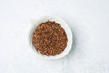 Nutrient-rich brown flaxseeds in a decorative bowl on a light countertop