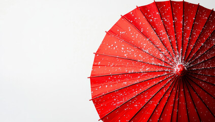 vibrant red umbrella is covered with delicate snowflakes against stark white background, creating striking contrast. scene evokes sense of calm and beauty