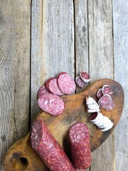 Wooden cutting board with sliced salami. High quality photo