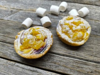 Small cakes with pineapple pieces on a wooden table