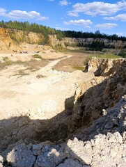 A vast quarry with layered rock formations and exposed earth, showcasing the raw beauty of industrial landscapes.