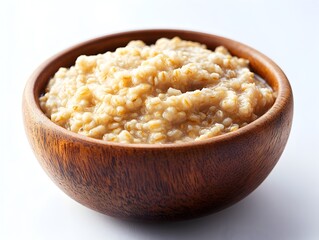 A steaming bowl of creamy oatmeal porridge sits in a rustic wooden bowl ready to be enjoyed for breakfast.