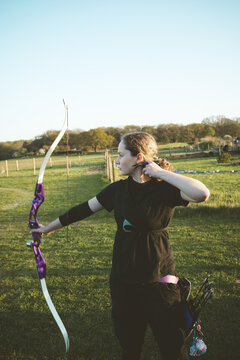 Teen age girl archer holding bow and arrow, training