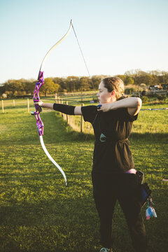 Teen age girl archer holding bow and arrow, training