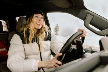 Smiling mom driving truck on winter day near slopes