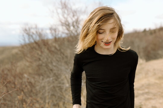 Teen boy walks with a smile on a breezy spring day