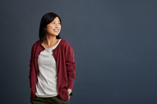 Confident smiling asian woman thinking and looking away