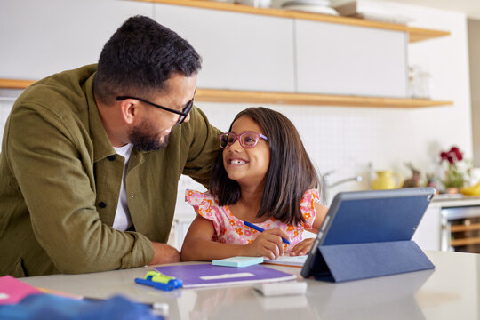 Father helping daughter in her study